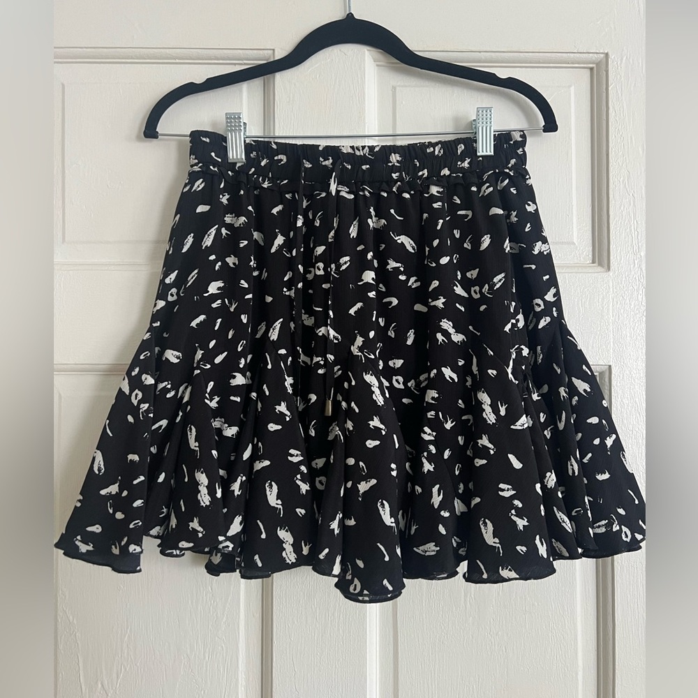 Skirt with built in shorts, elastic waist band and adjustable strings.